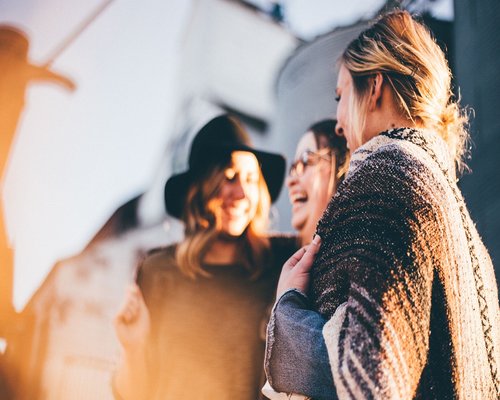 group of friends laughing together outside in nature with visual engagement